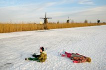 Children in skates laying on ice — Stock Photo