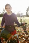 Mädchen läuft Fahrrad auf der Wiese, Junge im Hintergrund — Stockfoto