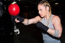 Boxerin schlägt Punchball in Turnhalle — Stockfoto