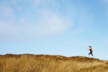 Mujer corriendo en ladera rural - foto de stock