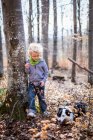 Хлопчик і собака досліджують в лісі — стокове фото