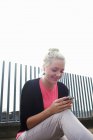 Жінка використовує мобільний телефон на міській вулиці — стокове фото