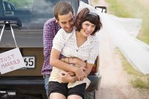 Newlywed couple by vehicle — Stock Photo