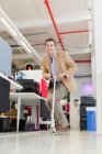 Geschäftsmann fährt Roller im Büro — Stockfoto