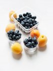 Apricots and blueberries in glass tumblers — Stock Photo