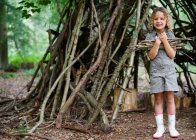 Young girl with pile of twigs in woods — Stock Photo