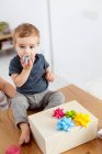 Toddler boy sitting with birthday present — Stock Photo