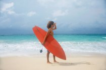 Людина, що перевозять дошки для серфінгу на тропічному пляжі — стокове фото