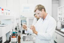 Scientifique examinant le liquide en laboratoire — Photo de stock