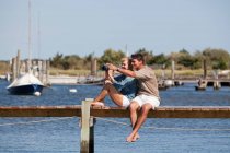 Couple sitting on a dock — Stock Photo