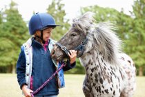 Giovane ragazza con il suo pony all'aperto — Foto stock