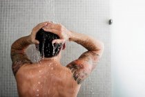 Man washing hair in shower, selective focus — Stock Photo