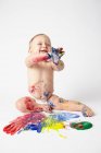 Baby playing with paints — Stock Photo