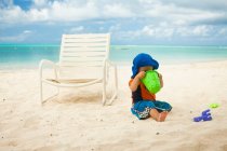 Petit garçon à la plage, regardant dans un seau — Photo de stock