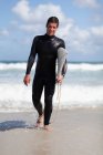 Teenager-Surfer trägt Brett am Strand — Stockfoto