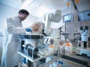 Un scientifique charge un échantillon dans un bain d'azote liquide prêt pour une radiographie en biolab — Photo de stock