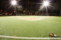 Campo de beisebol vazio iluminado à noite — Fotografia de Stock