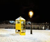 Телефонна будка на снігу вночі — стокове фото