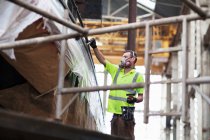 Arbeiter auf Gerüstlackierboot in Werft-Werkstatt — Stockfoto