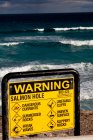 Fechar o sinal de aviso na praia . — Fotografia de Stock