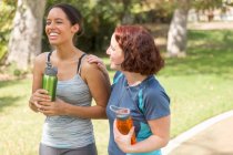 Blick aus der Vogelperspektive auf junge Frauen beim Spazierengehen in Sportkleidung mit lächelnden Wasserflaschen — Stockfoto