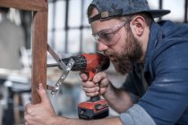 Cape Town, South Africa, close up craftsman drilling into wooden frame — Stock Photo