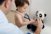 Маленький хлопчик і лікар використовують стетоскоп на іграшці панди — стокове фото