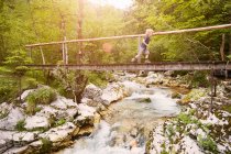 Niño corriendo sobre pasarela de madera, Bovec, Soca, Eslovenia - foto de stock