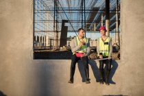 Будівельник і архітектор відпочивають на будівельному майданчику — стокове фото