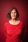 Портрет пожилой женщины на красном фоне — стоковое фото
