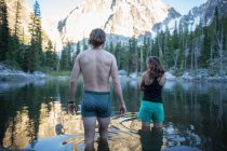 Молодий чоловік і жінка стоять в озері, задній вид, Зачаровані, альпійські озера пустиня, Вашингтон, США — стокове фото