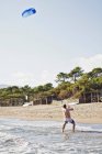 Uomo aquilone volante sulla spiaggia — Foto stock