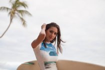 Молодая женщина держит доску для серфинга, портрет — стоковое фото