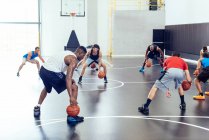 Entrenador masculino y equipo de baloncesto practicando en cancha - foto de stock
