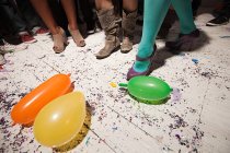 People dancing at party with balloons on floorboards — Stock Photo