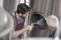Brewer cleaning out a stainless steel tank in the brewery — Stock Photo