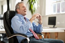 Businessman laughing at desk — Stock Photo