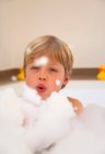 Мальчик играет с пузырьками в ванной — стоковое фото