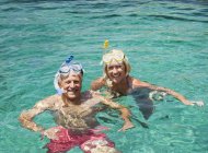 Coppia matura nuoto con snorkels — Foto stock
