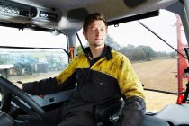 Фермер водит трактор в поле — стоковое фото