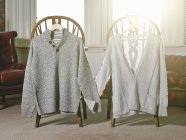Sweaters on coat hangers — Stock Photo