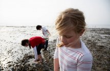 Niños jugando en la playa rocosa, enfoque selectivo - foto de stock