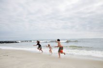 Niños corriendo en la playa, Holgate, Nueva Jersey, EE.UU. - foto de stock