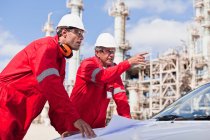 Arbeiter mit Bauplänen in Ölraffinerie — Stockfoto