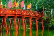 Rote Brücke über stillen Bach im satten Grün — Stockfoto
