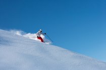 Esquiador montando en la ladera nevada - foto de stock