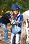 Young girl grooming her pony — Stock Photo
