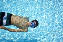 Мальчик в очках в бассейне — стоковое фото