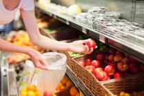 Donna che seleziona frutta al supermercato — Foto stock
