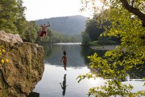 Casal jovem pulando de borda de rocha, Hamburgo, Pensilvânia, EUA — Fotografia de Stock
